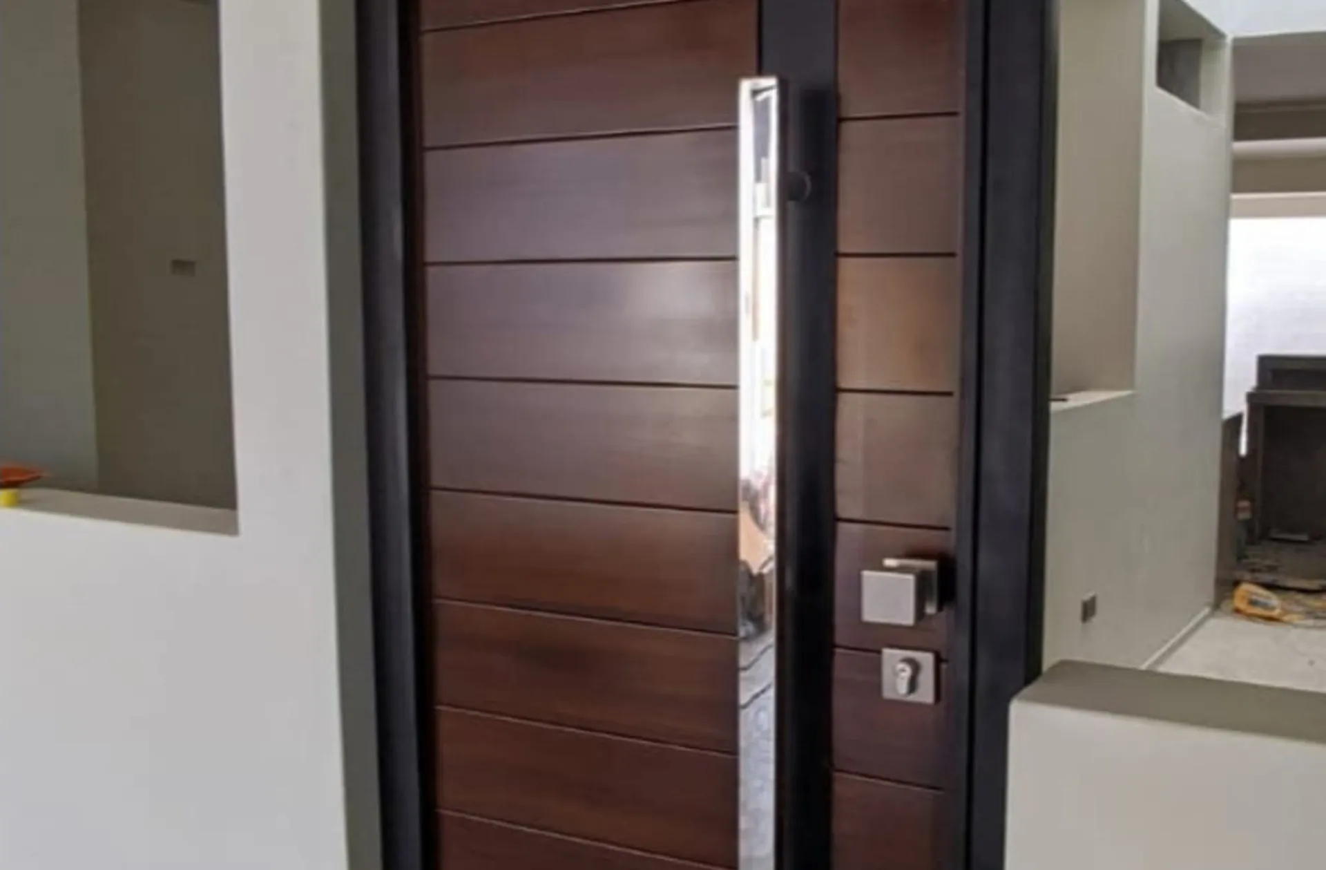Puerta de metal con acabado tipo madera y tirador largo de acero inoxidable